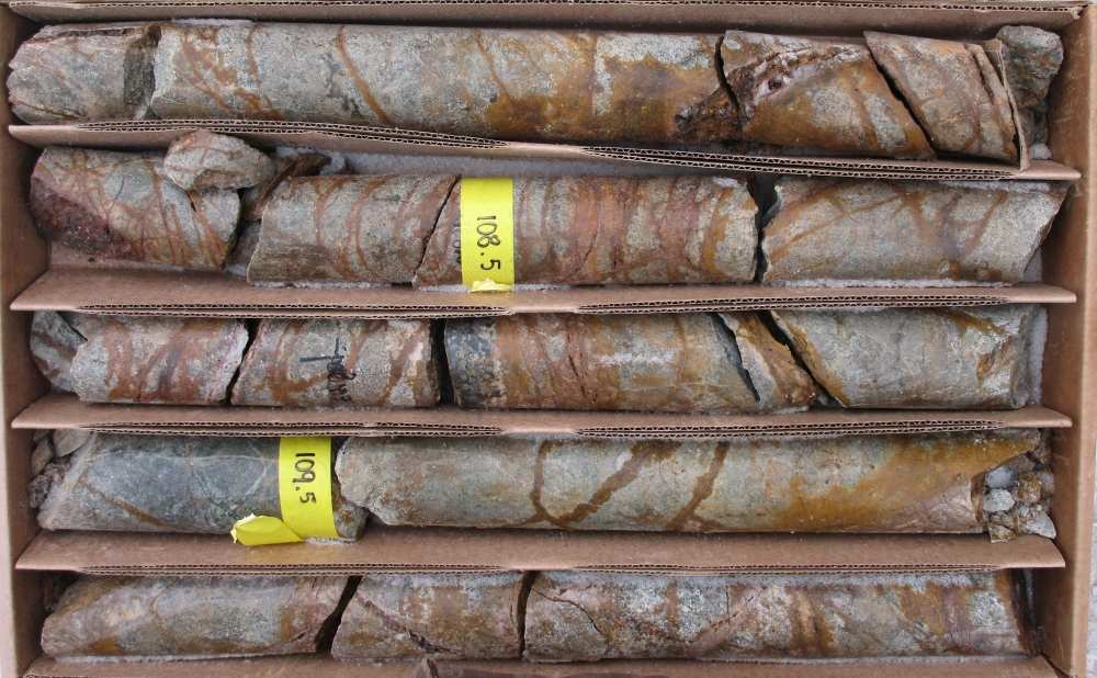 Styles of mineralization encountered in drilling. Shown are quartz-limonite-chalcopyrite (porphyry-style) veins cut by vuggy quartz-limonite veins (epithermal-style) intersected in drill hole IO-1.